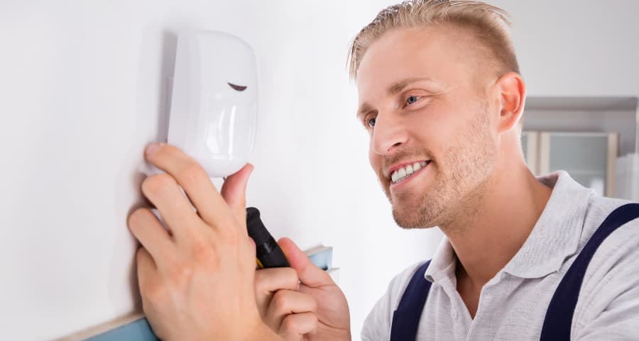 Man connecting a motion sensor inside a home